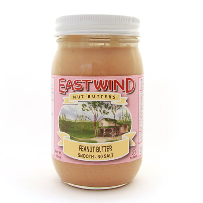 A 16 ounce glass jar of East Wind Nut Butters' Valencia peanut butter, smooth with no salt.