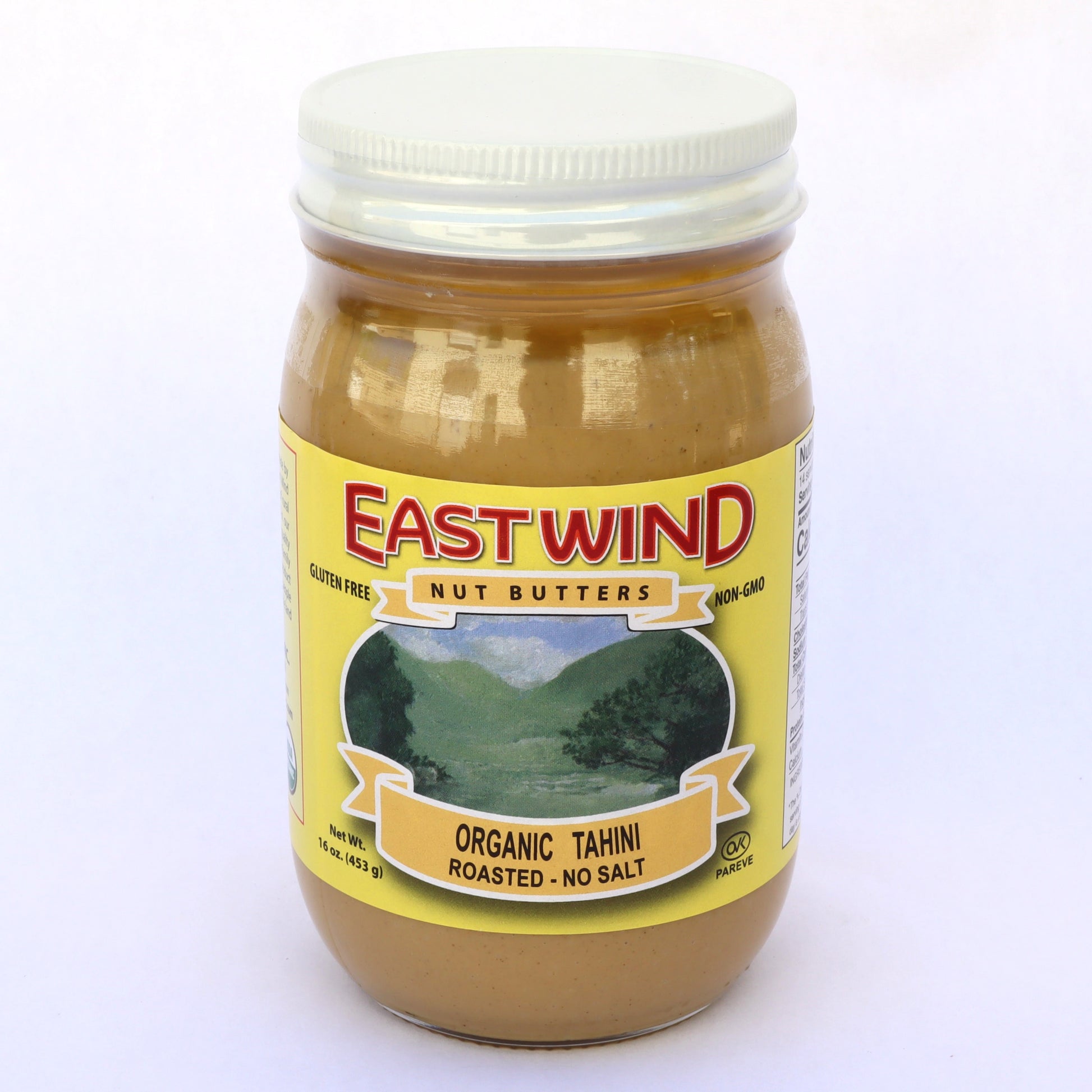 A 16 ounce glass jar of East Wind Nut Butters' organic tahini, roasted with no salt.